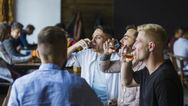 male-friends-enjoying-drinks-bar